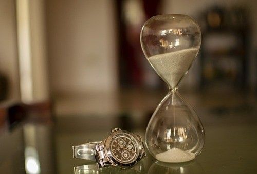 sablier à côté d'une montre